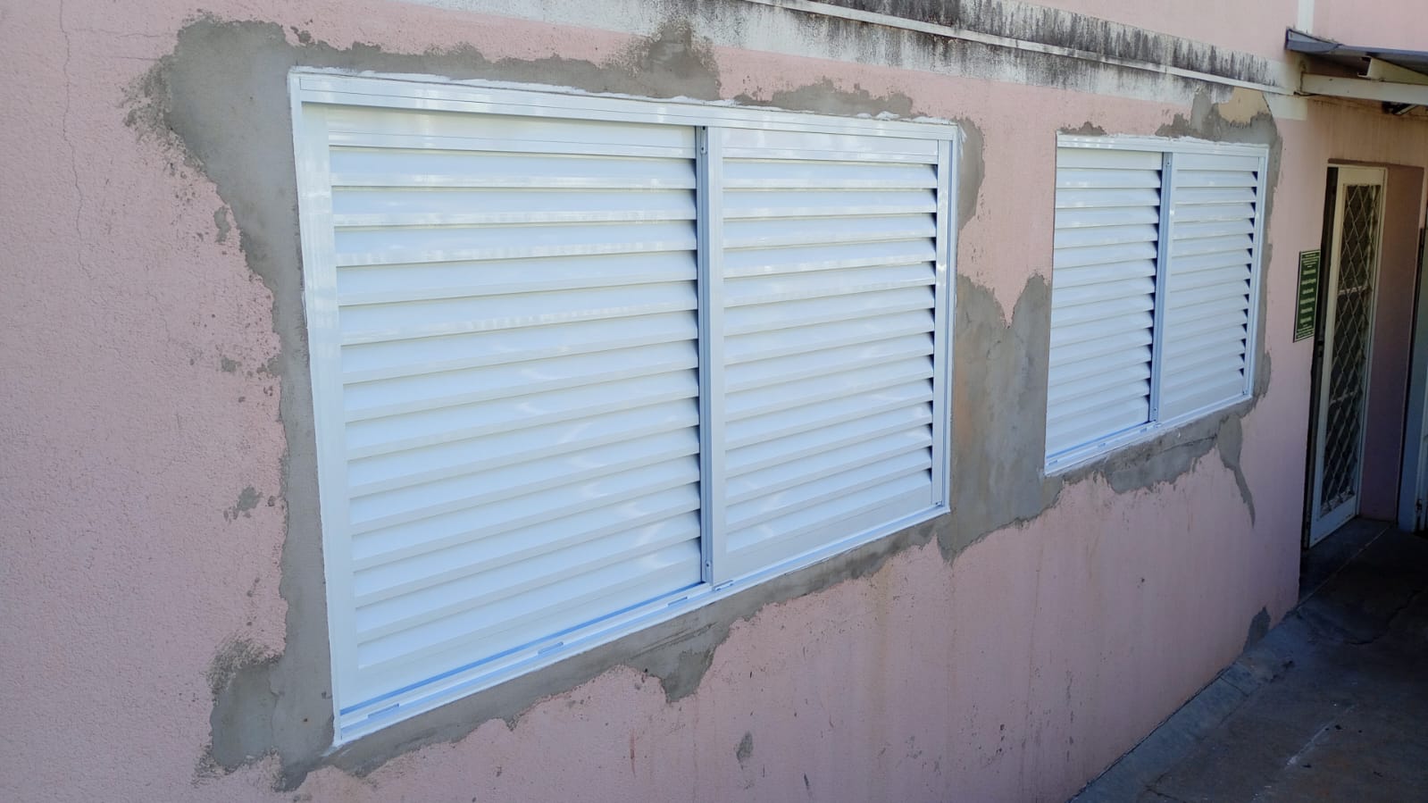 Janelas venezianas brancas recém-instaladas em fachada